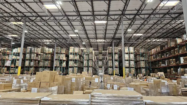Tactical Logistic Solutions warehouse with pallet racking and wrapped pallets of inventory staged on the floor